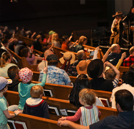 photograph of children sitting in a venue at the spring curiosity concert