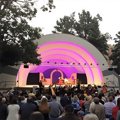 an opera singer performing at an outdoor venue in a park