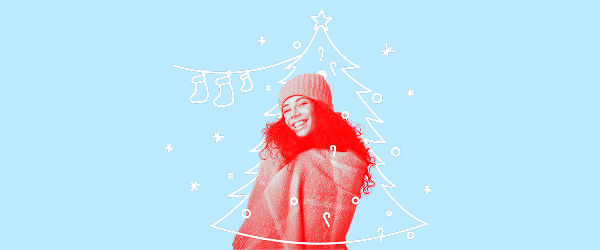 A smiling women wrapped in winter clothes stands in front of a doodle of a Christmas tree