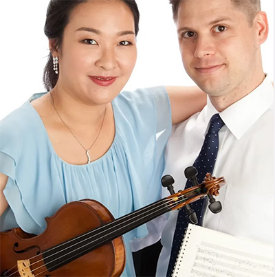 Susan Paik, holding a violen, sits next to Teddy Niedermaier